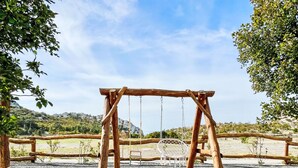 A wooden swing set in a park with a gravel ground and trees around. - Vacation home Iva by Interhome (Karlobag)