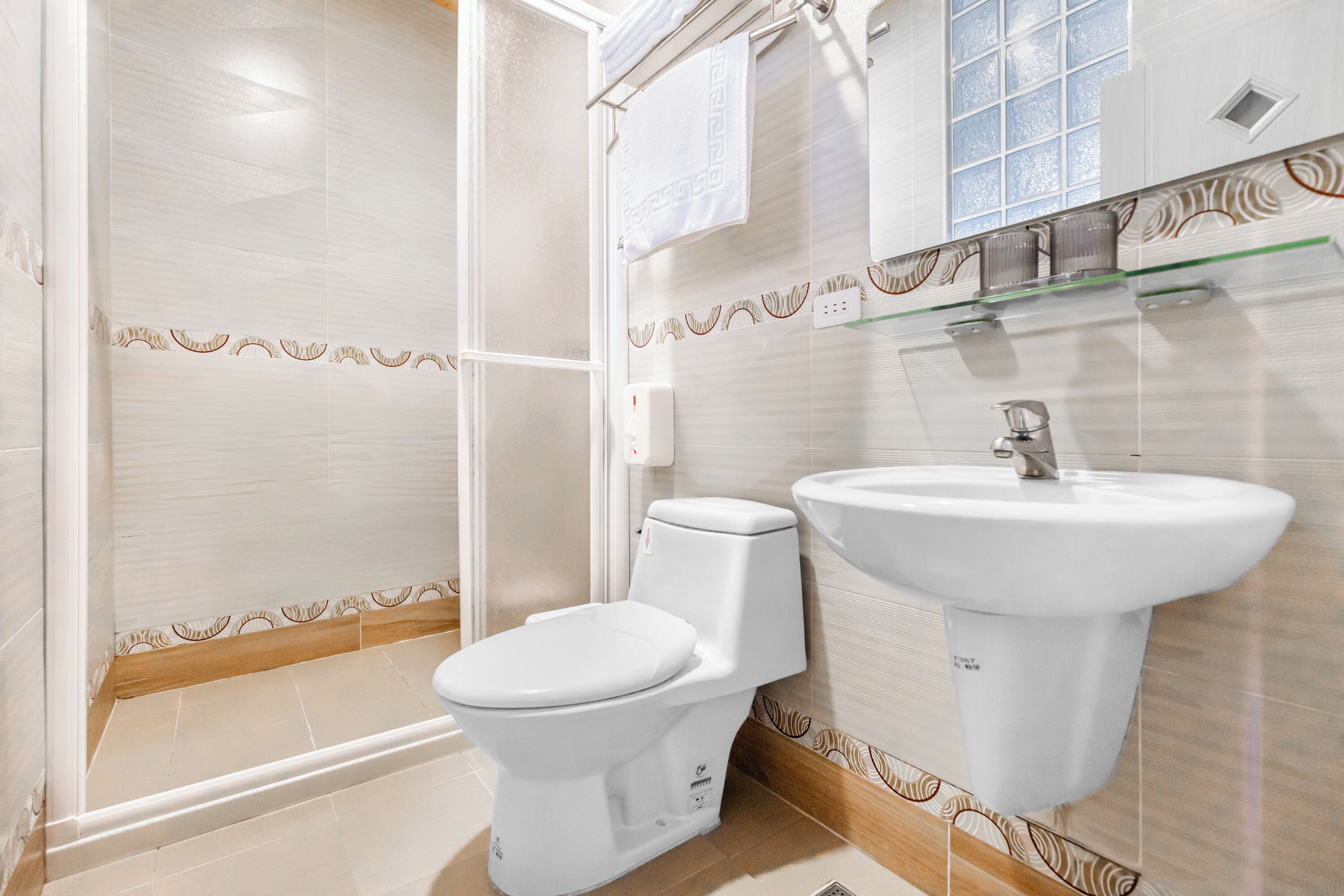 A modern bathroom with a shower, toilet, and sink.