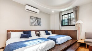 A hotel room with two beds, a large window with curtains, a wall-mounted air conditioner, and a painting. - Harmony Easy Stay (New Taipei City)