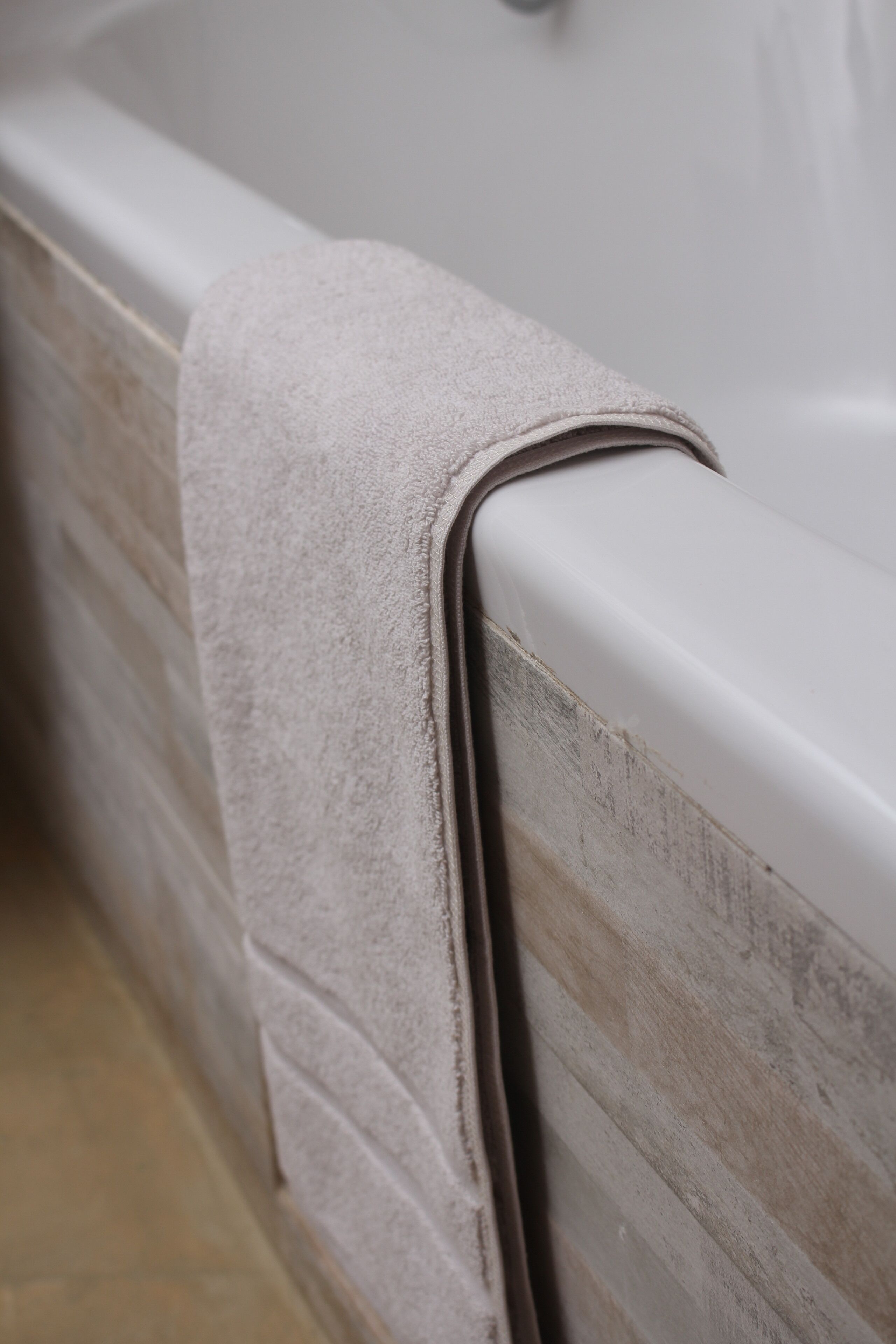 A bathtub with a towel draped over the edge.