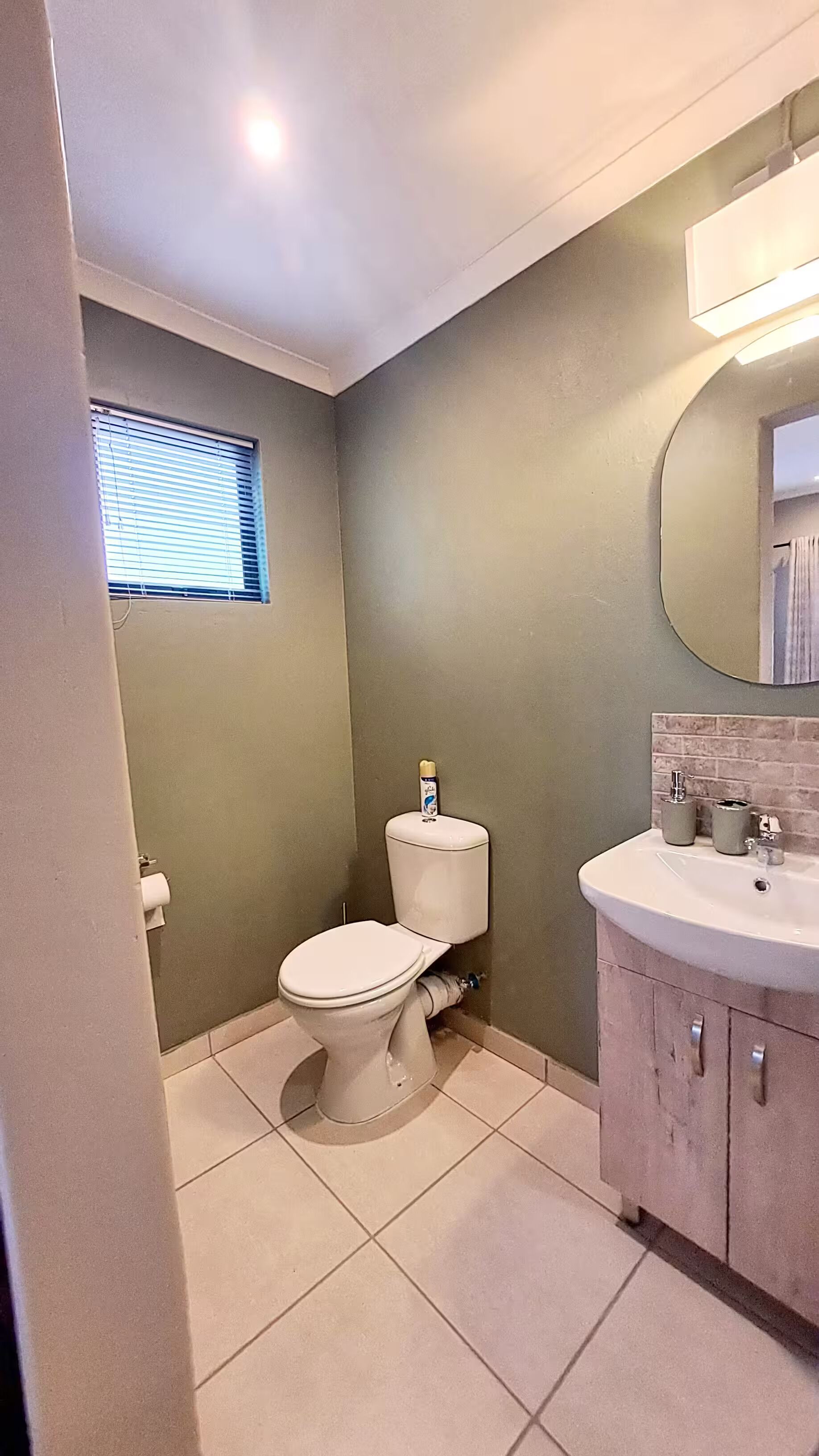 Un baño con inodoro, lavamanos y ventana.