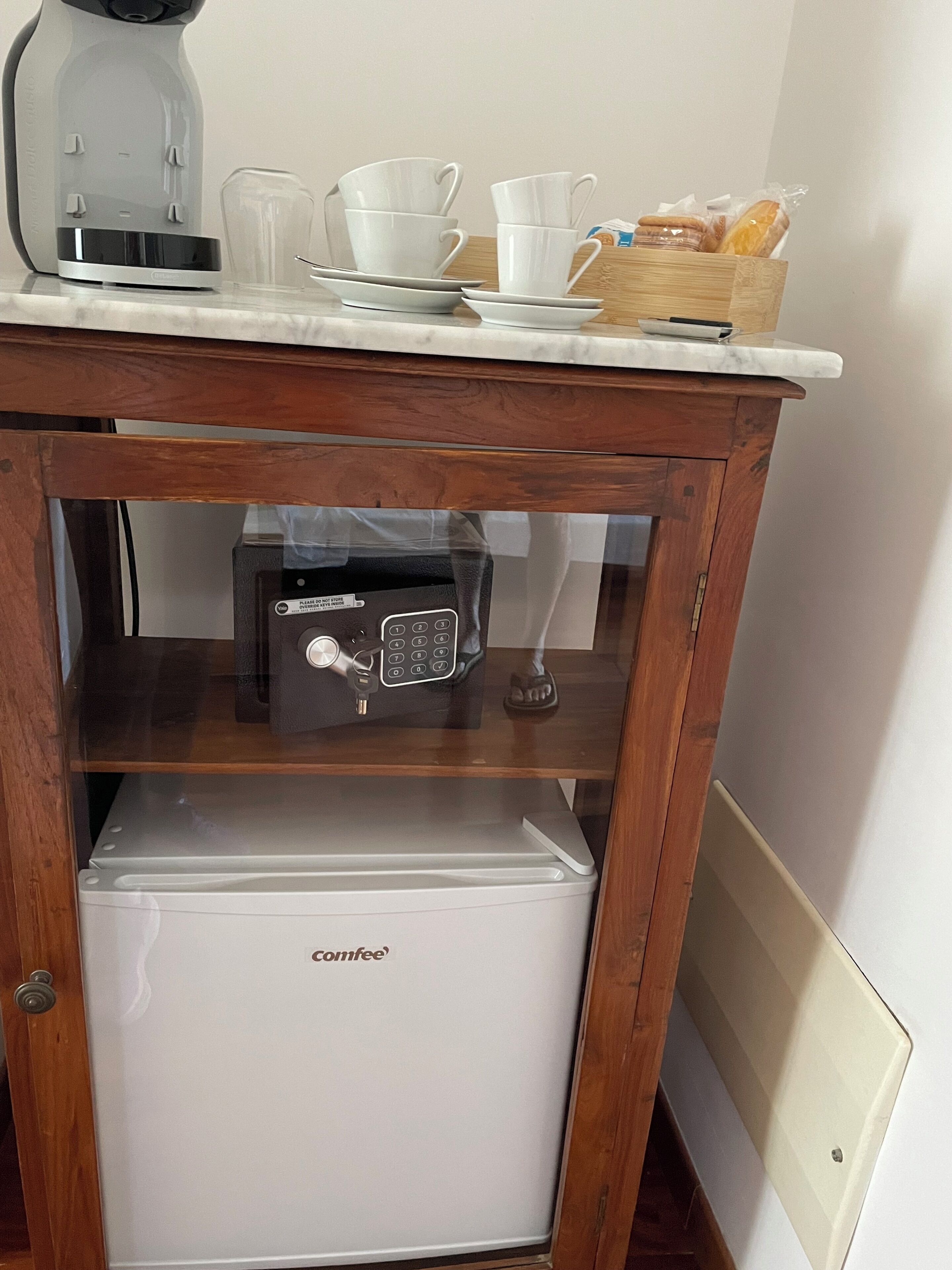 A compact kitchenette with a coffee maker, a toaster, and a mini-fridge.