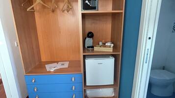 Un dressing avec des étagères en bois, une machine à café et un petit réfrigérateur.