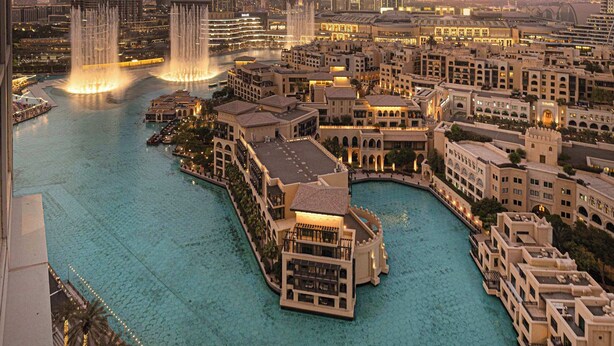 A cityscape with a prominent skyscraper, a waterfront area with buildings, and a body of water.