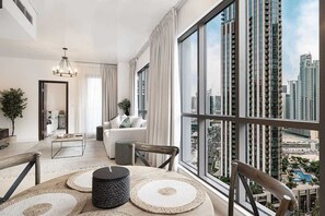 Ein modernes Wohnzimmer mit großem Fenster, einem Essbereich und Blick auf hohe Gebäude.
