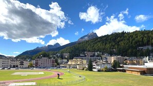 A town with a running track, buildings, and a mountain in the background. - Well-kept holiday apartament house in a prime location in St. (St. Moritz)