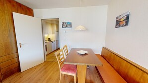 A compact kitchen with white cabinets, a wooden countertop, and a hanging light fixture. - Well-kept holiday apartament house in a prime location in St. (St. Moritz)