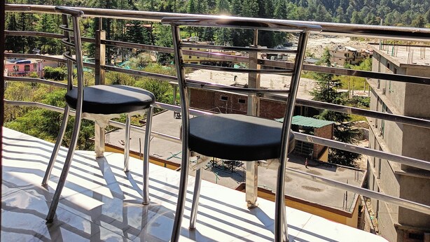 Ein Balkon mit zwei Stühlen mit Blick auf eine Berglandschaft.
