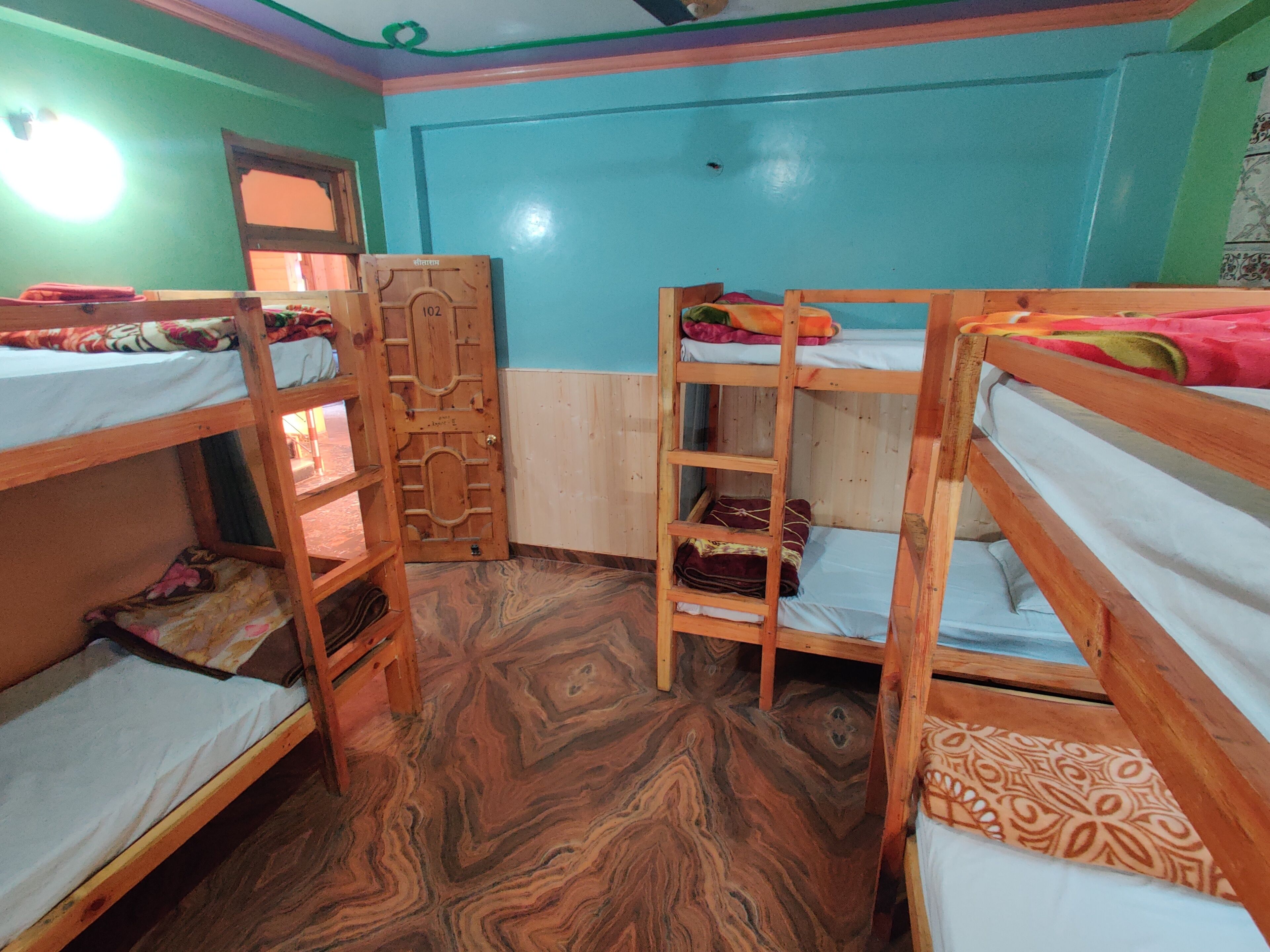 Una habitación con literas, una escalera de madera y un suelo estampado.