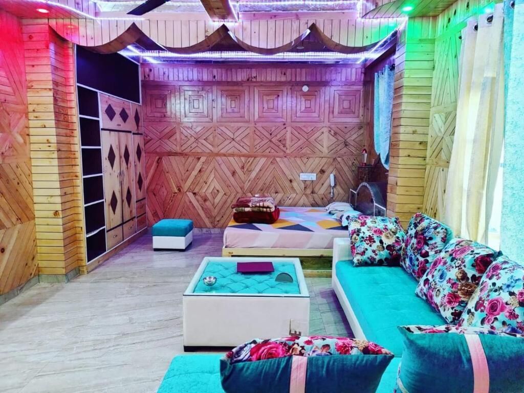 Een knus vertrek met een houten wandpaneel, een bank, een kleine tafel en een bed.