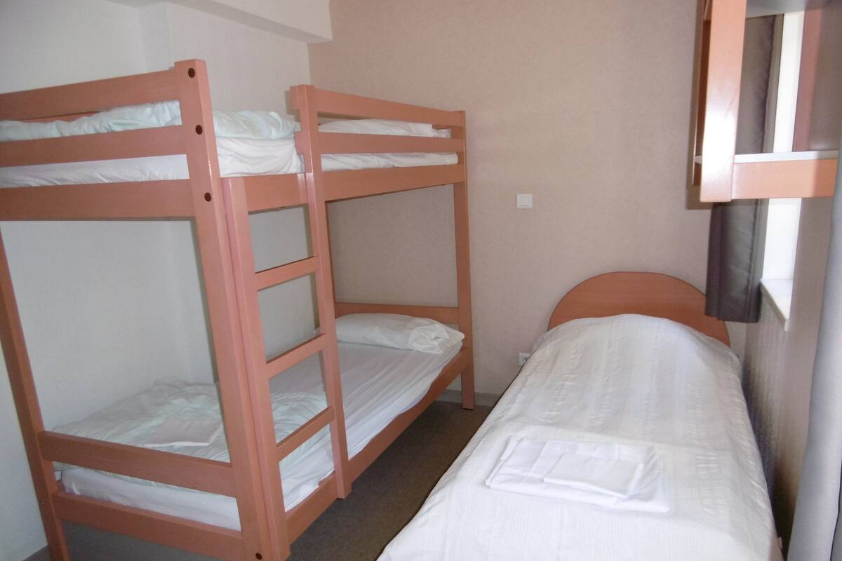 A room with two bunk beds and a single bed.