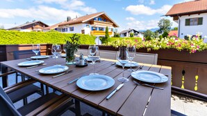 A dining table set outdoors with plates, cutlery, and wine glasses. - NEW: Exclusive vacation home at Lechsee in the Allgäu (Lechbruck am See)