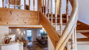 A wooden staircase with a curved design leading to an upper level. - NEW: Exclusive vacation home at Lechsee in the Allgäu (Lechbruck am See)