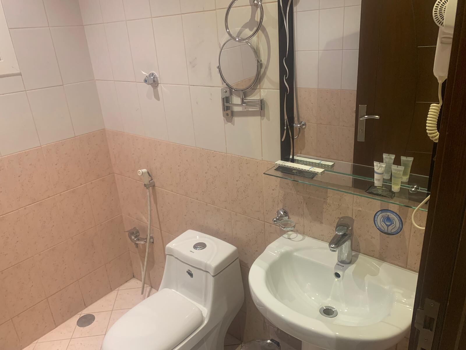 A bathroom with a toilet, sink, and shower.