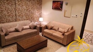 Una sala de estar con dos sofás, una mesa de centro y una pared decorada.