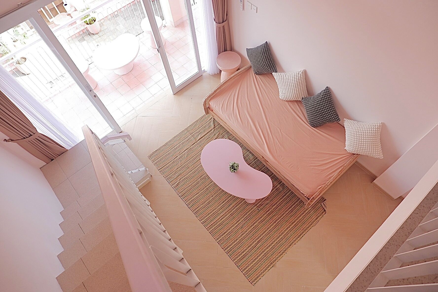 A bedroom with a bed, a small round table, and a view of the outside.