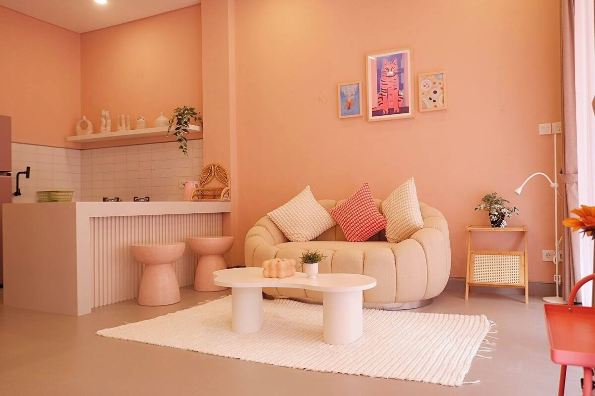 A modern living room with a beige sofa, a round coffee table, and a small side table with a plant.