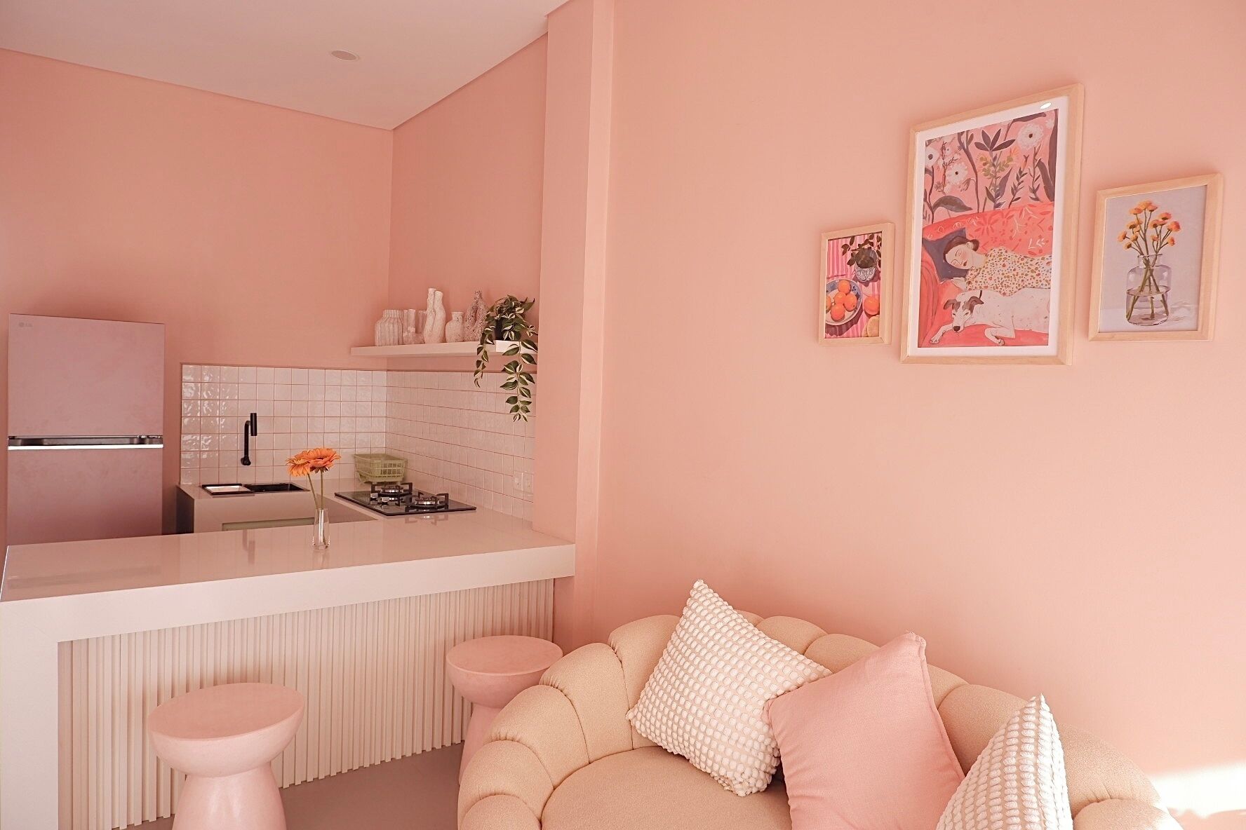 A modern kitchen with a pink theme, featuring a refrigerator, sink, and stove.