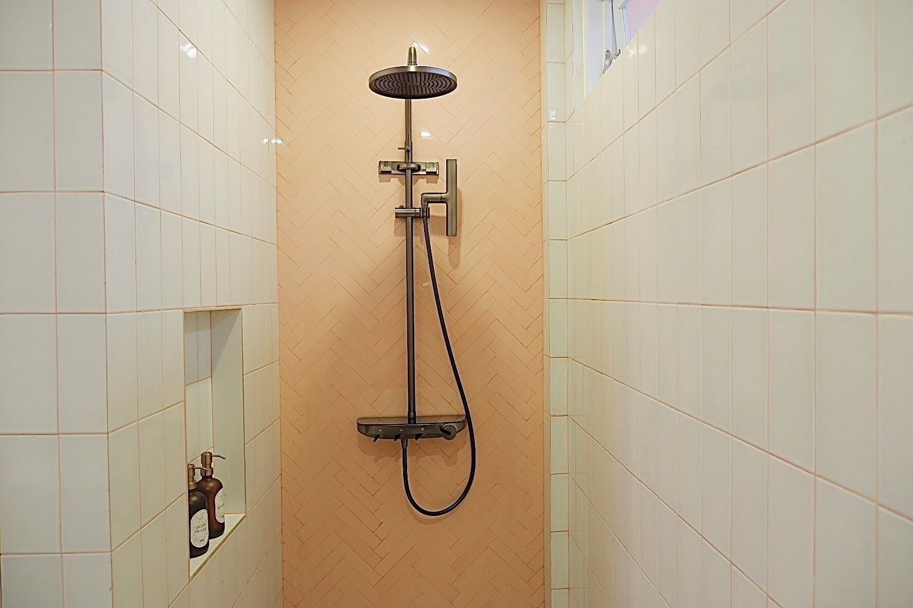 A shower with a handheld showerhead and a handheld hose.