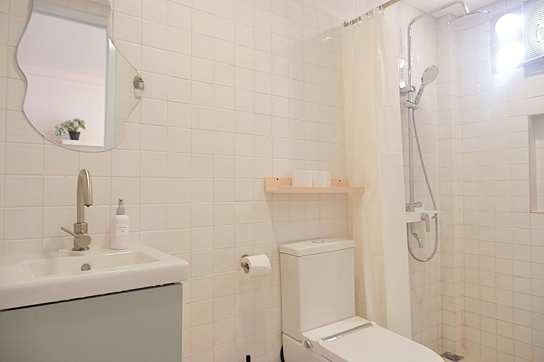 Un baño con lavamanos, inodoro y ducha.