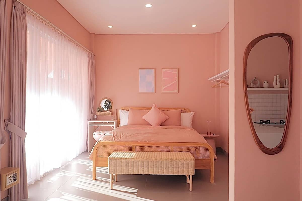 A bedroom with a bed, bedside table, and a mirror.