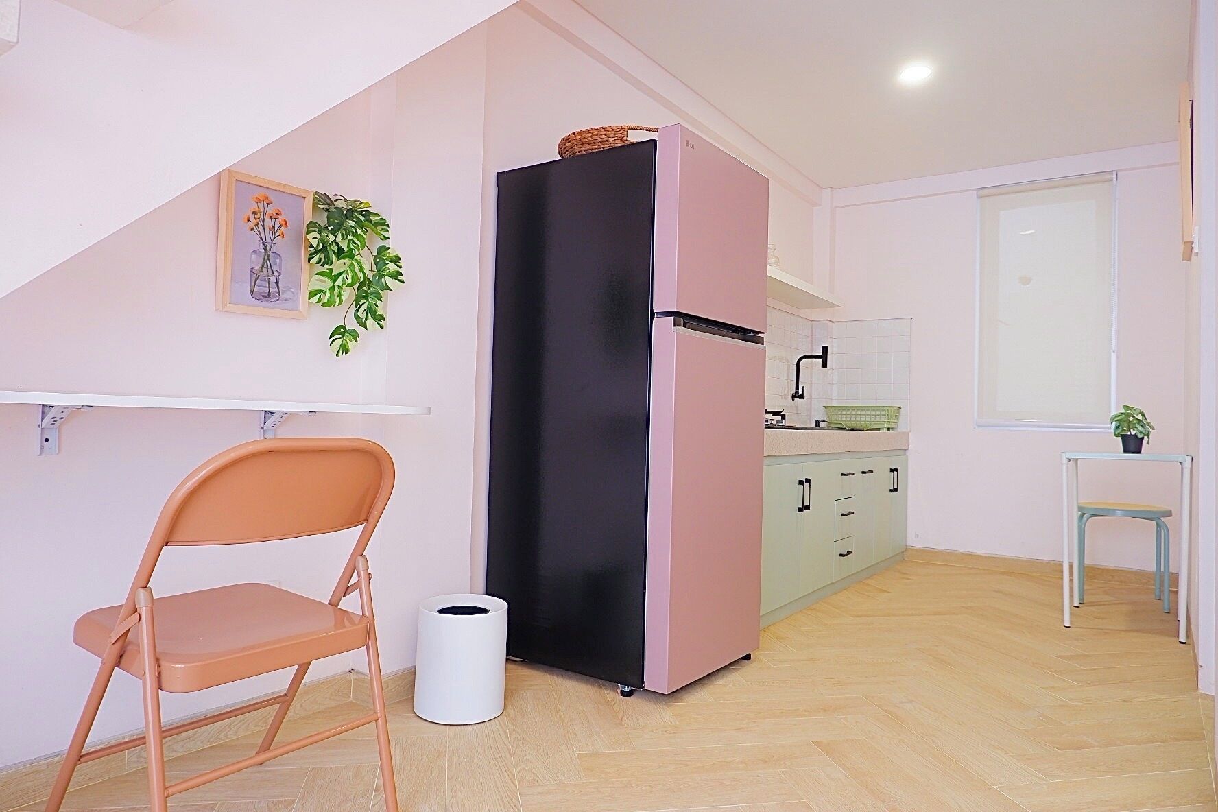 A compact kitchen with a refrigerator, a sink, and a dining area.
