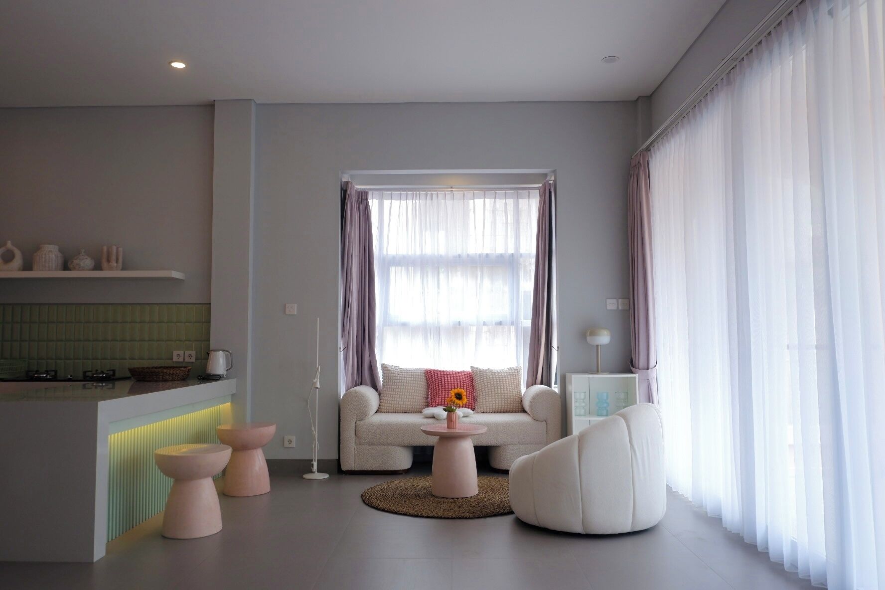 Una sala moderna con un sofá, una mesa de centro y una zona de comedor con mostrador de cocina.