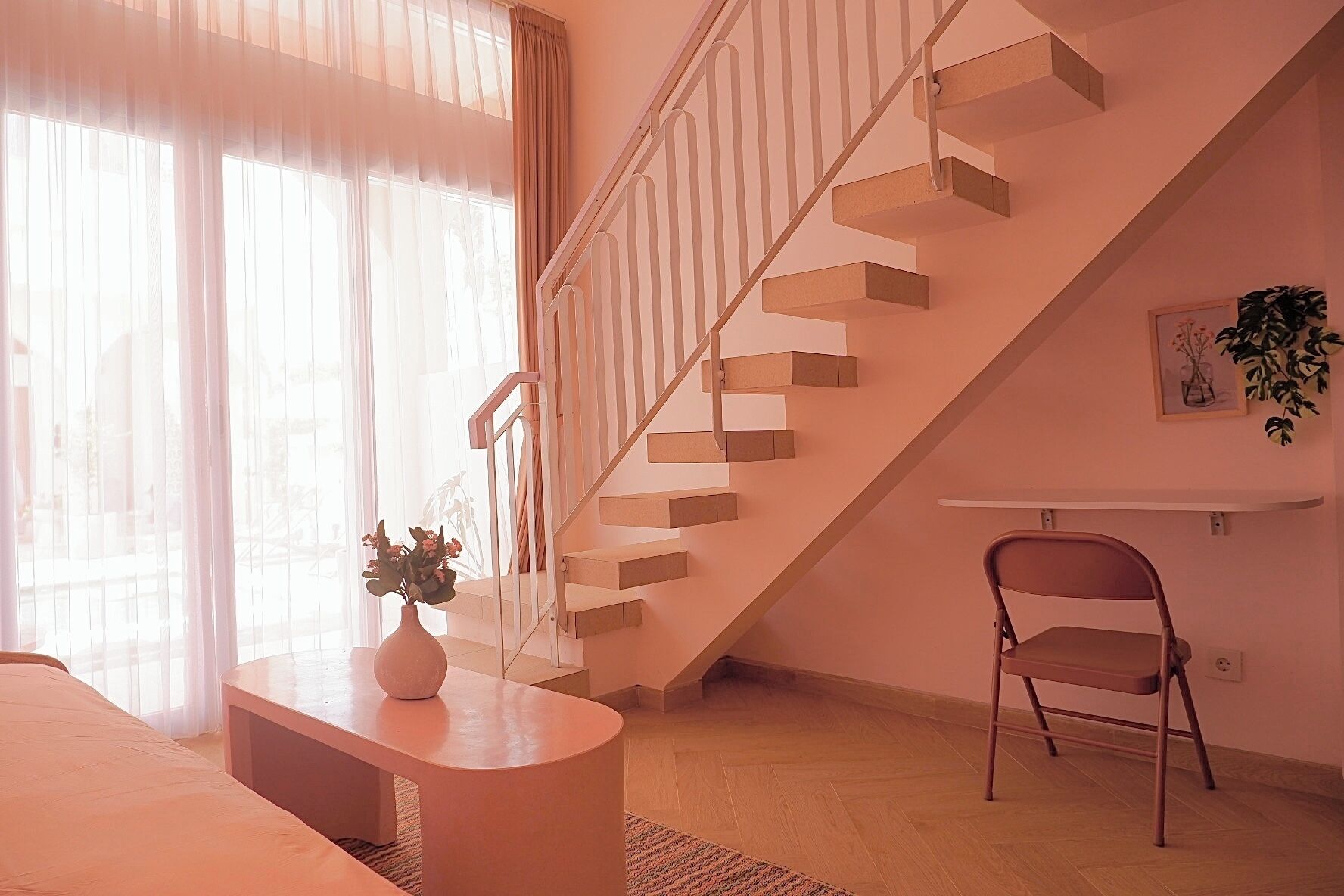 A modern living room with a staircase, a sofa, a coffee table, and a chair.