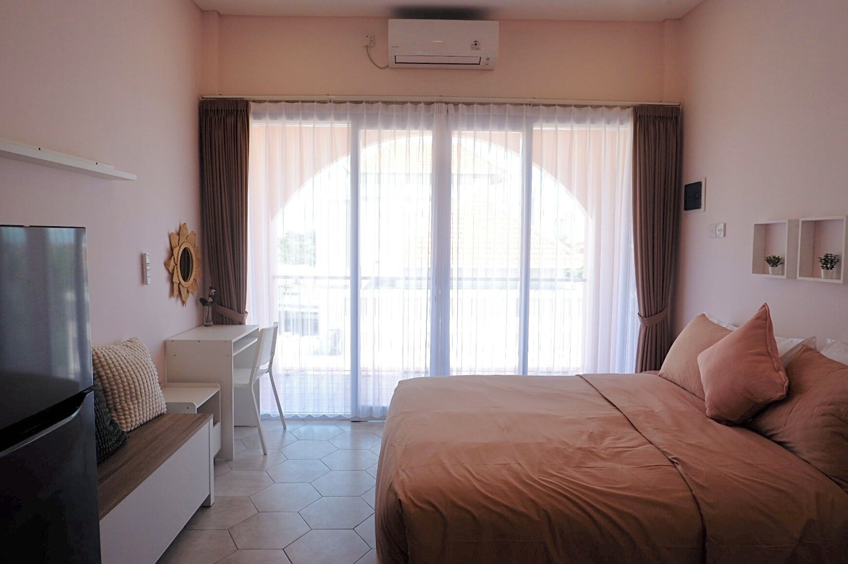 A hotel room with a bed, a desk, a chair, and a television.