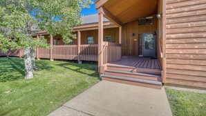 A wooden building with a covered porch and a concrete pathway leading to the entrance. - Spacious Condo with Spectacular Mountain Views! Great Uptown Location!  Sleeps 8!! (Pagosa Springs)