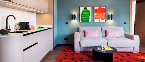 A modern apartment with a kitchen, a sofa, and a coffee table.