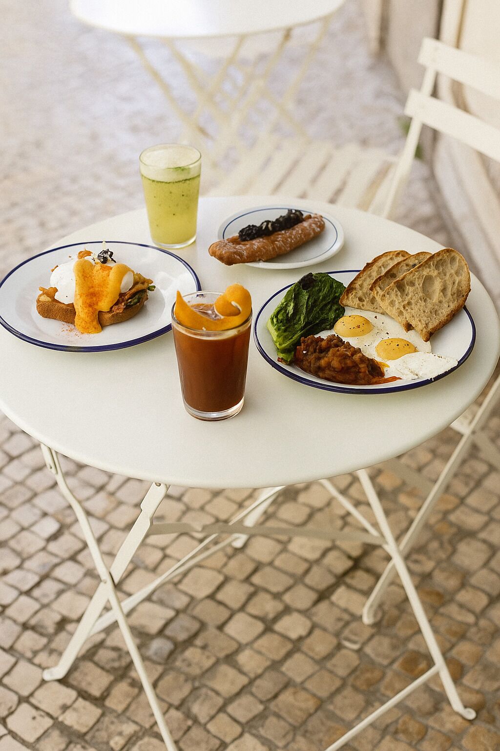 A table with plates of food, a drink, and a small dessert.