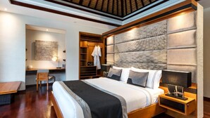 A modern bedroom with a large bed, bedside tables, a desk, and a walk-in closet.