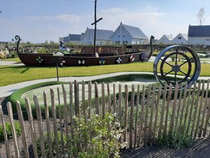 Guests can enjoy a serene garden setting with a traditional boat, rustic fence, and ornate wheel.