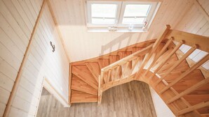 A wooden staircase in a room with white walls and a window. - Schwalbennest - Infrared Sauna, Fireplace, 4 Sun Loungers, EV Charging Station (Olpenitz)