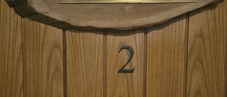 A wooden door with a metal plaque reading "Blåenscherchan" and the number "2" on it.