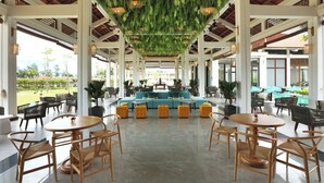 A spacious indoor area with a central seating area, multiple tables, and chairs.