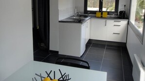 A modern kitchen with white cabinets, a black countertop, and a window providing a view of the outdoors.