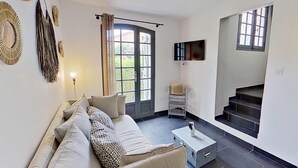Un salon moderne avec un canapé, une table basse et un escalier menant à un niveau supérieur.