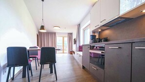 Una cocina moderna con comedor, piso de madera y vistas al exterior.