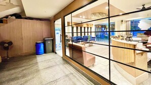 A modern lobby with a reception desk, seating area, and a view of the outside. - RB INTERNATIONAL - PURI near Sea Beach (Puri)