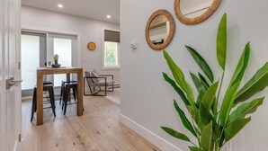 Un intérieur moderne comprenant un coin repas, deux miroirs fixés au mur et une grande plante verte.