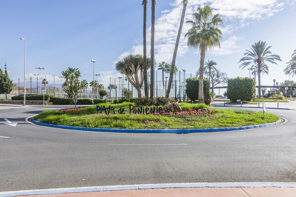A landscaped area with a sign reading "Playa de Poblano." - A&N California (Torre del Mar)