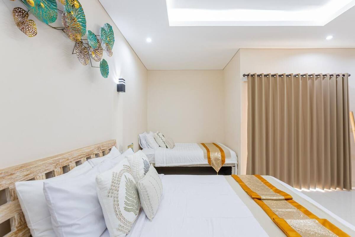 Habitación de hotel con dos camas, un tragaluz, un ventanal grande con cortinas y decoración en la pared.