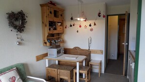 Una cocina acogedora con muebles de madera, microondas y teléfono.