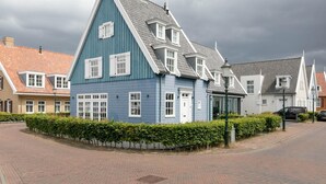 A traditional Dutch house with a steep gable roof, a small porch, and a brick pathway leading to the entrance. - Cottage mouse (Hoofddorp)