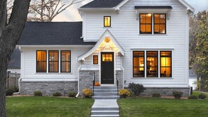 A two-story house with a stone foundation, a black front door, and a number '2900' above the entrance. - Cottage mouse (Hoofddorp)