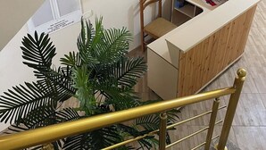 A modern interior with a staircase, a reception desk, and a seating area. - Canary Hotel (Golem)