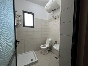 Driepersoonskamer, uitzicht op tuin | Badkamer | Een douche, een haardroger, handdoeken, zeep