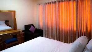 A hotel room with a bed, a desk, a chair, and a large mirror. - House - Sleeps 10 - Parking - Airport Close (Accra)